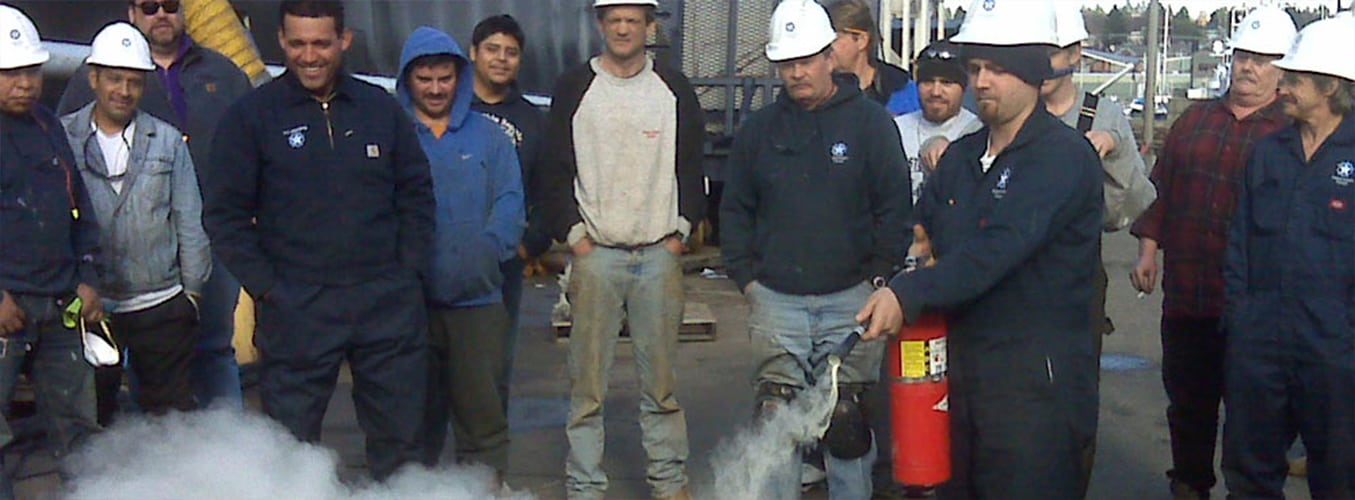 group of men using a fire extinguisher